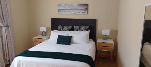 a bedroom with a large white bed with two night stands at Shalom Self catering in Cape Town