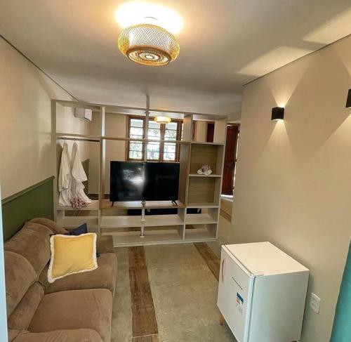 a living room with a couch and a flat screen tv at Recanto dos manacas in Pirenópolis