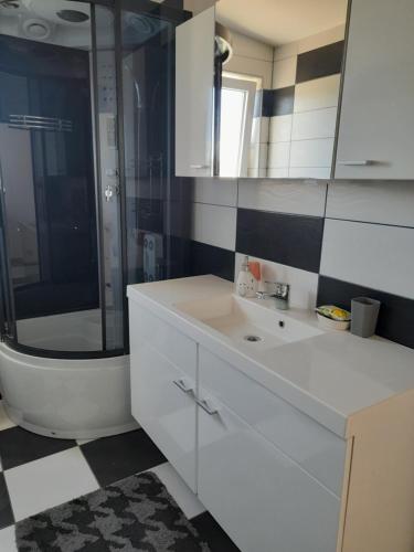 a bathroom with a white sink and a shower at loren in Pirovac