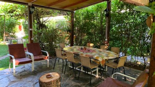 einen Tisch und Stühle auf einer Terrasse unter einem Pavillon in der Unterkunft Cabaña Salto del Laja 