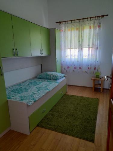 a bedroom with a bed with green cabinets and a green rug at loren in Pirovac