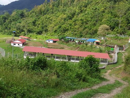 a building with a red roof on a mountain at Gorkha Organic Agro Farm in Gorkhā
