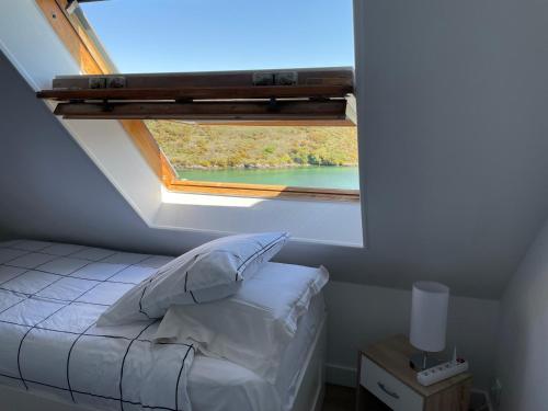 Appartement T3 vue mer Sauzon balcon et parking privé في Sauzon: سرير في غرفة مع نافذة كبيرة