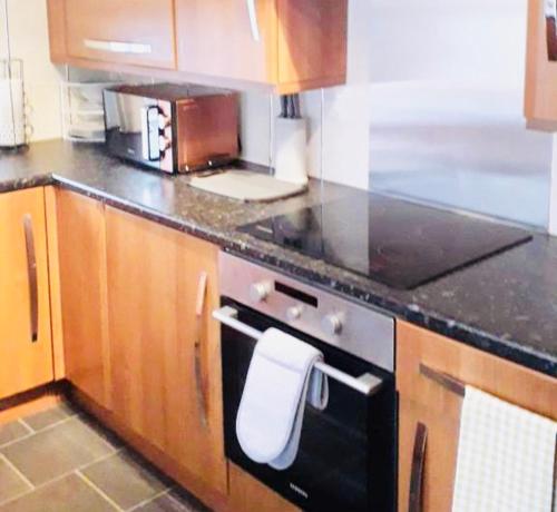 a kitchen with a stove with a white towel on it at Gardiner Cottage in Prestwick