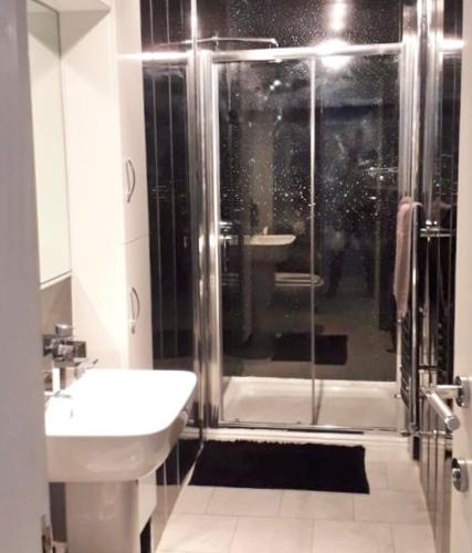 a bathroom with a shower and a toilet and a sink at Gardiner Cottage in Prestwick