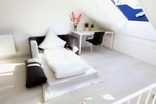 ein Wohnzimmer mit einem weißen Sofa und einem Schreibtisch in der Unterkunft Messezimmer Hannover / Private rooms for exhibitions in Hannover