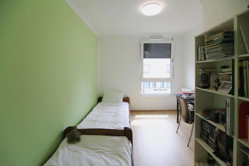 Zimmer mit 2 Betten, einem Schreibtisch und einem Fenster in der Unterkunft Messezimmer Hannover / Private rooms for exhibitions in Hannover