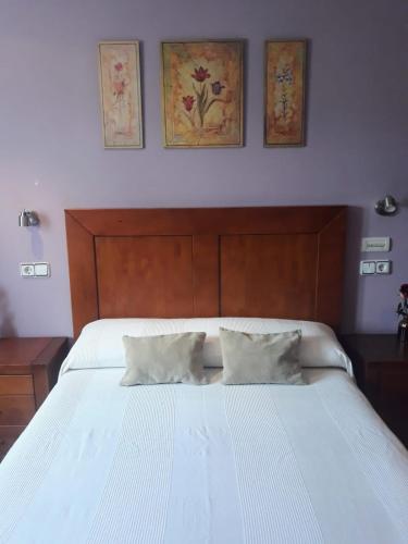 a bedroom with a large white bed with two pillows at O DESCANSO DE MANDUCA in Mazaricos