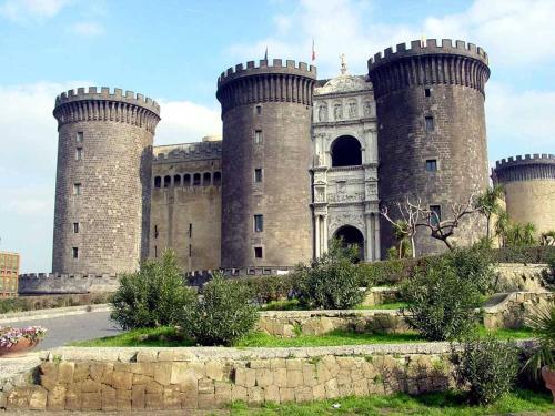 Un gran castillo con tres torres encima. en Mecla Suites en Nápoles