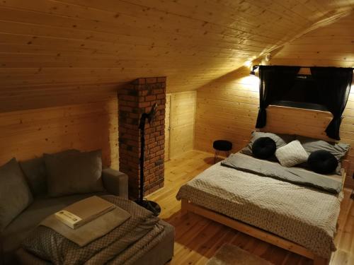 1 dormitorio con 1 cama y 1 sofá en una habitación en Na Zakręcie - Domek Loft, en Błędowo