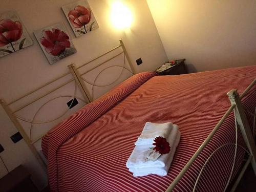 una camera da letto con un letto rosso con un fiore rosso di Azienda Agricola Cuntarati a Bronte