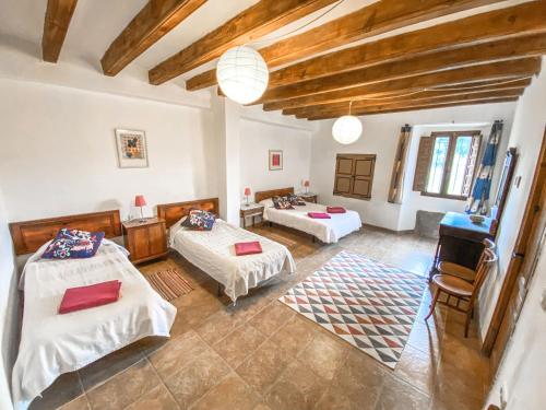 Habitación grande con 2 camas y mesa. en Casa Rural Sant Petrus de Madrona, en Pinell de Solsonès