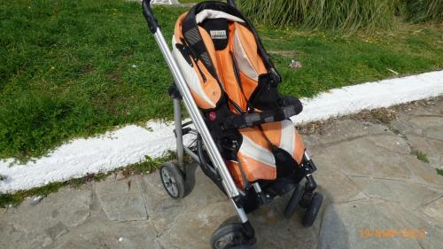 an orange and white stroller sitting on a sidewalk at Villa Georgius in Néon Rýsion