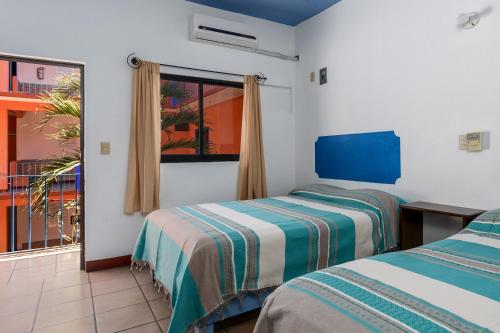 A bed or beds in a room at Hotel Costamar, Puerto Escondido