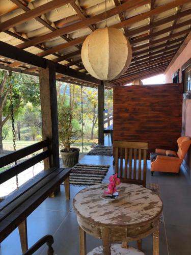 Zimmer mit einer Bank, einem Tisch und einer Lampe in der Unterkunft Fazenda Quinta da Esperança- Pousada e Lazer in Tiradentes