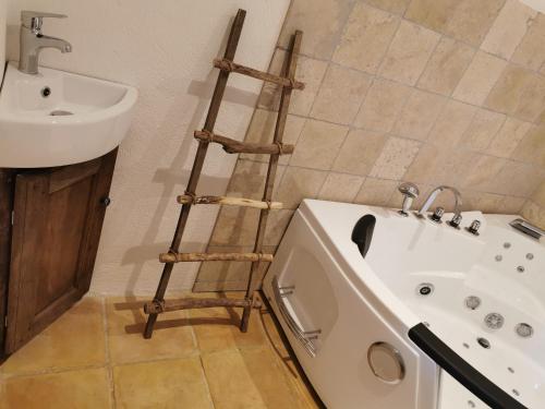 a bathroom with a wooden ladder next to a sink at La Bastide du Capelier - Chambres d'hôtes avec baignoire balnéothérapie - 3 étoiles in Salernes