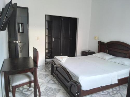 - une chambre avec un lit, une table et un bureau dans l'établissement HOTEL DORADO PUERTO BERRIO, à Puerto Berrío
