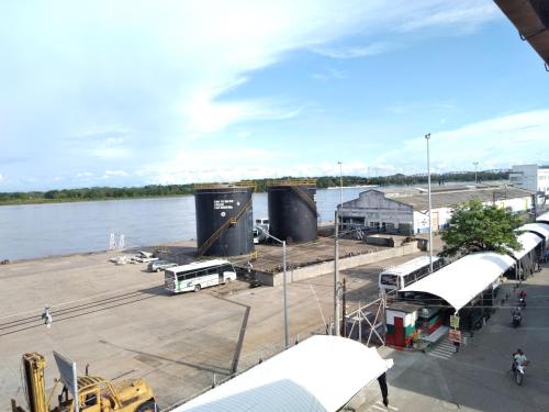 un quai avec des bus et des camions sur l'eau dans l'établissement HOTEL DORADO PUERTO BERRIO, à Puerto Berrío