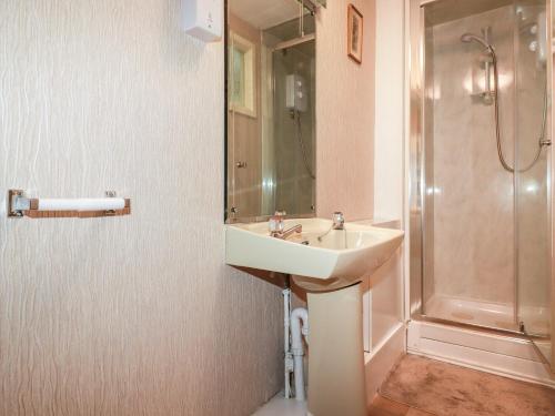 ein Badezimmer mit Waschbecken und Dusche in der Unterkunft The Ark Cottage in Par