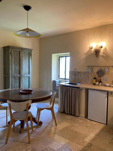 - une cuisine avec une table et des chaises dans la chambre dans l'établissement Tenuta Folesano Wine Estate 13th century, à Marzabotto