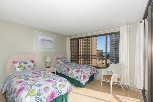 1 Schlafzimmer mit 2 Betten und einem Fenster mit Aussicht in der Unterkunft Two Bedroom Discovery Bay High Rise Condos with Lanai & Gorgeous Views in Honolulu