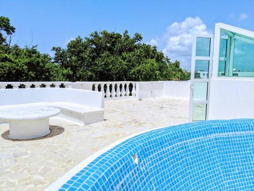 un patio con un banco y una mesa en 9br 6ba Large groups! Best location in town Walk to beach, 5th ave Cozumel ferry, shopping, nightlife! Roof plunge pool!! Castillo Playacar Fase 1 25max, en Playa del Carmen