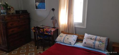 a bedroom with a bed and a desk and a window at Faneromeni Two bed Apartment B (1st Floor) in Zakynthos Town