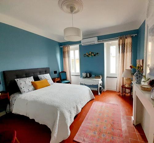 a bedroom with blue walls and a bed with a yellow pillow at Villa Saint Léon in Badens