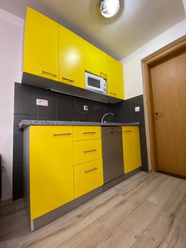 a kitchen with yellow cabinets and a microwave at Lighthouse in Vodice