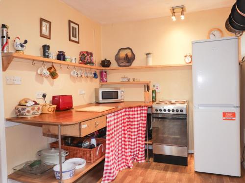 a kitchen with a refrigerator and a table with a microwave at Recroy in Nedd
