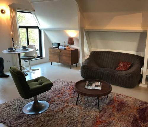 a living room with a couch and a chair and a table at Boutique B&B in Edam in Edam