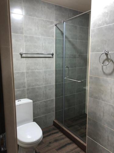 a bathroom with a toilet and a glass shower at The Friends in Yerevan