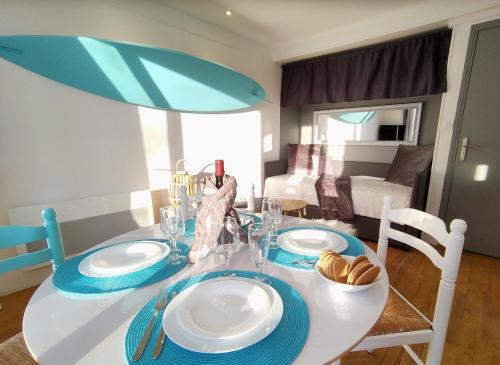 une table à manger avec des plaques bleues et blanches dans l'établissement SURF Vue Mer 100m plage, à Berck-sur-Mer