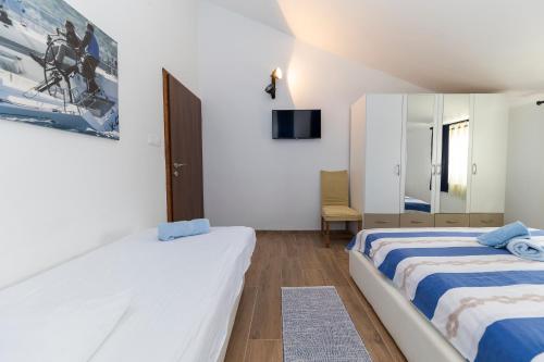 a bedroom with two beds and a mirror at Apartman Lana in Biograd na Moru