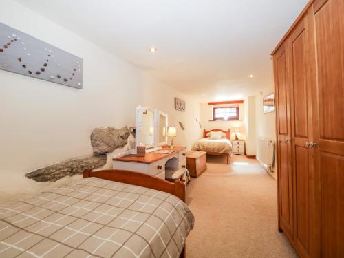 a bedroom with a bed and a desk in a room at Raceside Cottage in Silecroft