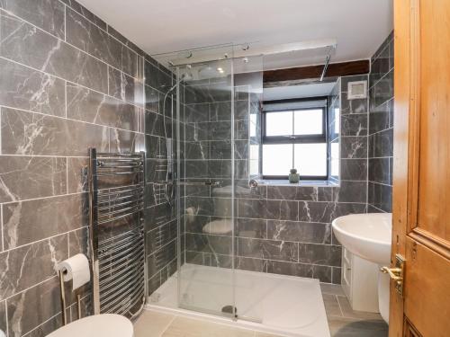a bathroom with a shower and a toilet and a sink at Raceside Cottage in Silecroft