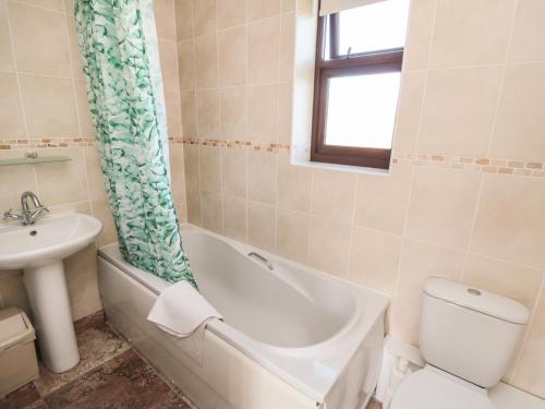 a bathroom with a tub and a toilet and a sink at The Calf House in Boosbeck