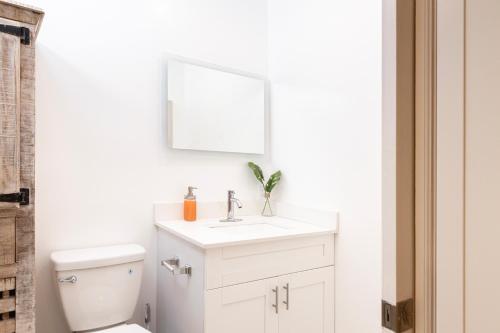 a white bathroom with a sink and a toilet at Beautiful Casita with King Bed and private patio Close to Calle 8, MIA Airport, Coral Gables in Miami