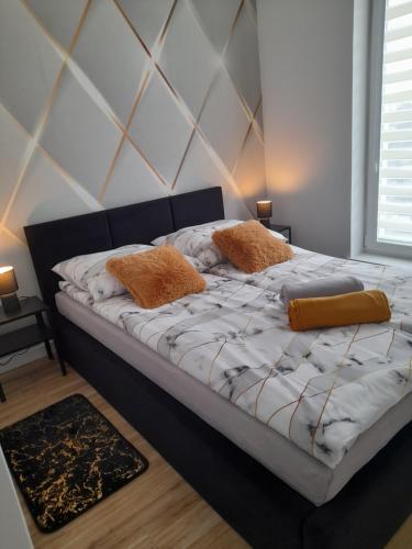 a bed in a bedroom with two pillows on it at Apartamenty Bartoszyce 2 in Bartoszyce