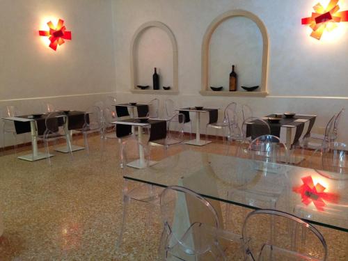 a room with tables and chairs and two mirrors at Momi's Hotel in Cavarzere