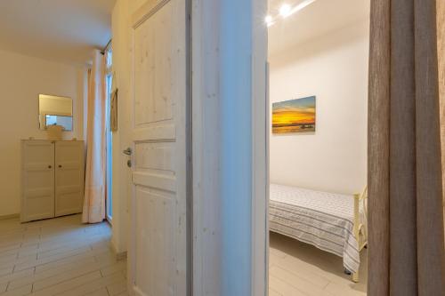 a bedroom with a bed and a painting on the wall at Leuca Mon Amour in Leuca