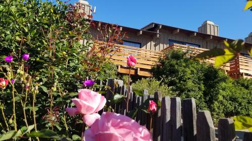 a fence with pink flowers in front of a building at Carmel Valley Lodge in Carmel Valley