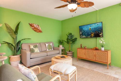 a living room with green walls and a couch at Alii Villas 201 in Kailua-Kona