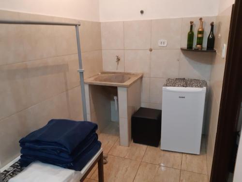 een kleine badkamer met een wastafel en een kleine koelkast bij Pousada Chácara Famille Brun in São João da Boa Vista