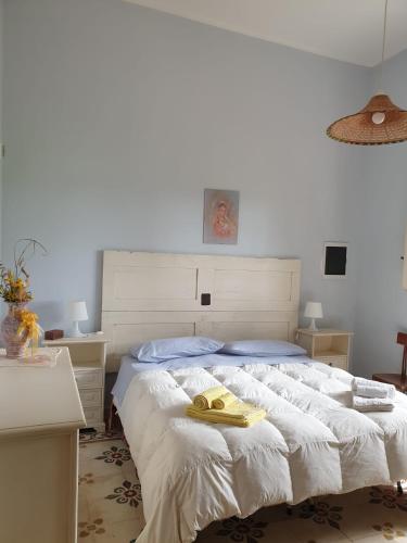 a bedroom with a bed with a yellow robe on it at Masseria Vivi il Salento in Santa Caterina di Nardò