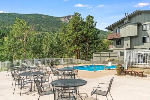 a patio with tables and chairs next to a pool at Fall River Casita in Estes Park