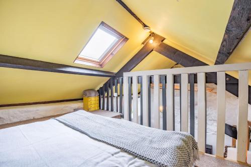 - une chambre avec un lit bébé et une fenêtre dans l'établissement Celyn Farm Cottage, à Cwm-y-glo