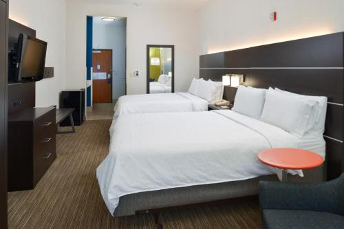a hotel room with two beds and a television at Holiday Inn Express Madera, an IHG Hotel in Madera