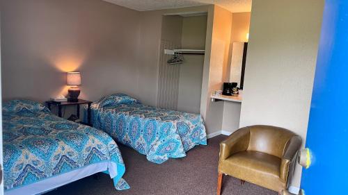 um quarto de hotel com duas camas e uma cadeira em Alpine Motel room,Wifi,Sandy Beach,Boat Ramp,Pier and Marina,Bath House with Laundromat em Hemphill