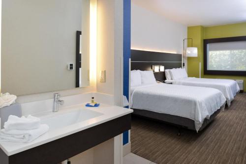 a hotel room with two beds and a sink at Holiday Inn Express Madera by IHG in Madera